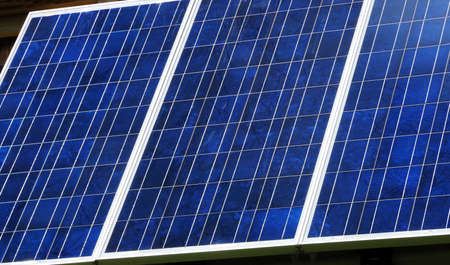 Panel of blue photovoltaic cells receiving sunlight.