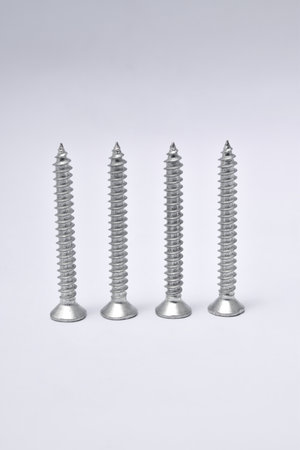 Close-up on screws, metal screws, iron screws, isolated on whited background. Flat Head