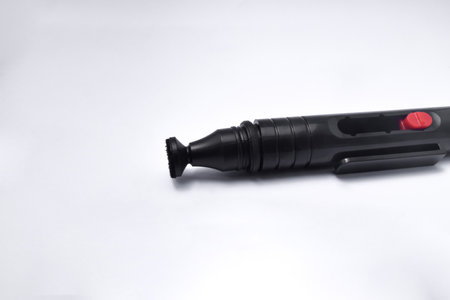 black and red lens pen, closeup and isolated on white background. camera equipment for cleaning lensesの写真素材