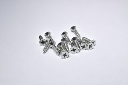 Close-up on screws, metal screws, iron screws, isolated on whited background. Flat Head