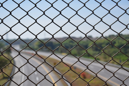 Chain link fence on flyover with highway blur backgroundの写真素材