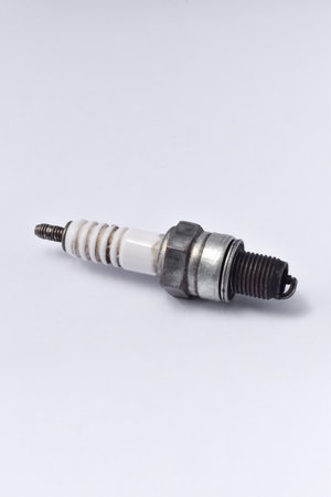 Used motorcycle spark plug isolated on white background.