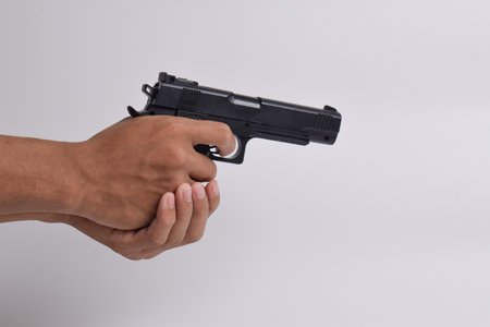 Two-handed holding pistol isolated on white background. A Pistol in a man's hand