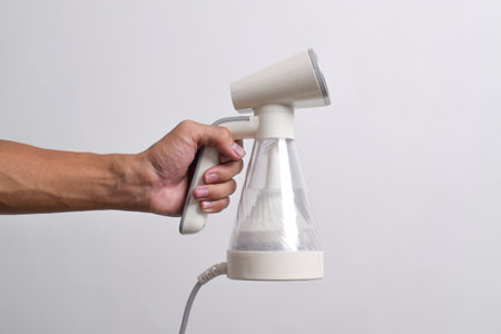 Hand steamer for clothes isolated on a white background. Portable home and travel garment steamer...
