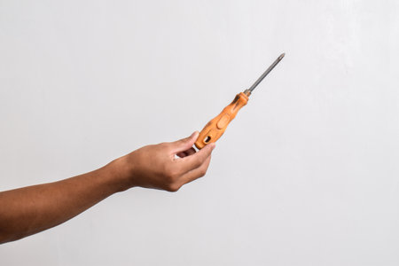 Hand holding Old screwdriver isolated on white backgroundの写真素材