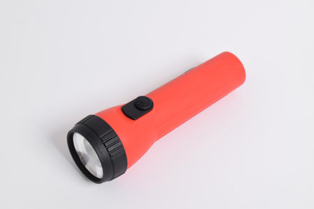 Red color flashlight isolated on white background. Red Battery-powered flashlightの写真素材
