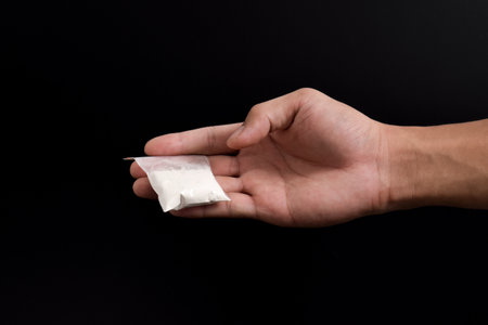 Hand giving cocaine in plastic package isolated on black background. Illustration of illegal drug...