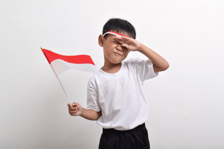 Cute little Asian boy giving salute celebrate Indonesian independence day on August 17 isolated on white backgroundの写真素材