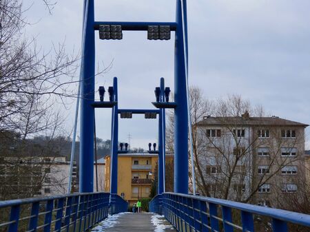 Blue pedestrian cable bridge over Alzette river in Walferdange, Luxembourg, winter dayの写真素材