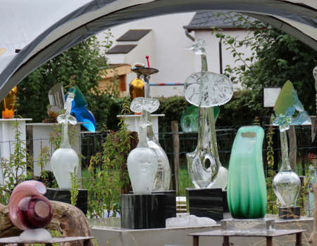 Asselborn, Luxembourg - August 15, 2019. International glass art festival by Emeringer atelier. Fine glass works on display and for sale in countryside environment with tomatoes and sting nettles growingのeditorial素材
