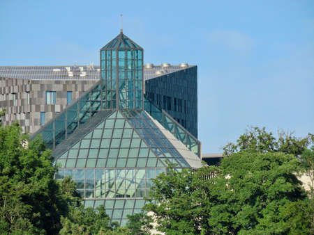 Kirchberg, Luxembourg, Luxembourg - July 4, 2019. Glass roof of Modern Art museum MUDAM among green trees lit by afternoon sunshineのeditorial素材