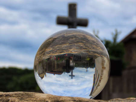 Medieval castle ruin in Pettingen, Luxembourg seen through crystal ball. The cut glass holder further distorts the image inside the ballの写真素材