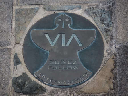 Way marker Follow Via Epternacensis in Latin, English, and French, on sidewalk in town of Echternach, Luxembourg - August 29, 2020のeditorial素材