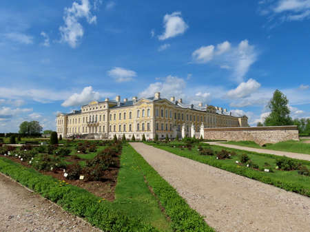Rundale in Latvia: yellow and white Baroque style palace built for Dukes of Courland by Bartolomeo Rastrelli, view from French gardens, sunny spring day. Rundale, Latvia - May 22, 2021のeditorial素材