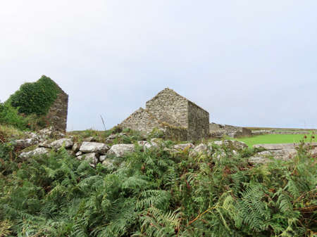 Empty moore landscape in England with stone walls and old house in the distanceの写真素材