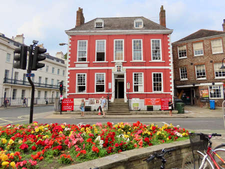 Red house Antique centre in York, England, UK - September 9, 2021. Red building with signs, flower bed in foreground.のeditorial素材