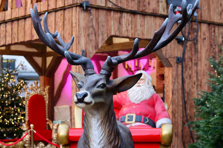 Plastic reindeer head, behind him blurry Santa in sledgeの写真素材