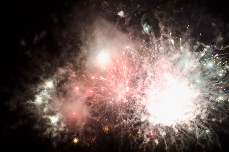 Fireworks in small town on New Years eve. Dark night, long exposure