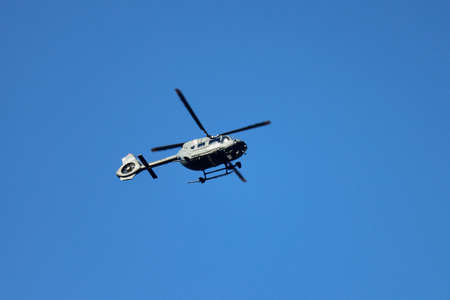 Police helicopter patrolling in the blue sky over Luxembourg, Luxembourg - February 12, 2022のeditorial素材