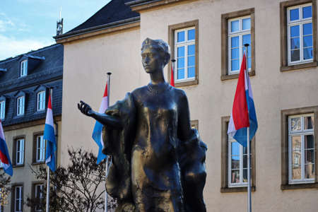 Bronze statue of Grand Duchess Charlotte with national flags behind, designed by French sculptor Jean Cardot. Luxembourg, Luxembourg - February 12, 2022のeditorial素材