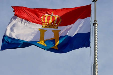 Luxembourg flag with monogram H and crown, flown to celebrate National day and Grand Dukes Henry official birthday. Luxembourg, Luxembourg - June 23, 2022の写真素材