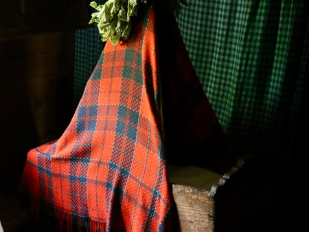 Red checkered blanket over old wooden cradle. Latvian Ethnographic Open Air museum, Riga, Latvia - May 27, 2022のeditorial素材