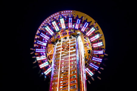 Top of Hangover the Tower Ride with people in it. Motion blur of the moving lights. Schueberfouer fun fair in Luxembourg, Luxembourg - August 28, 2022のeditorial素材