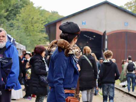 Woman with plush toy ferret on shoulder in a group of Steampunk convention visitors in Fond-de-Gras,...