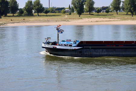 Cargo boats in Rhine river on a sunny summer day, low water conditions due to prolonged draught. Dusseldorf, North Rhine-Westphalia, Germany - September 2, 2022のeditorial素材