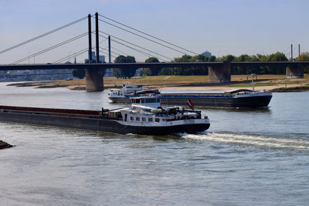 Cargo boats in Rhine river on a sunny summer day, low water conditions due to prolonged draught. Dusseldorf, North Rhine-Westphalia, Germany - September 2, 2022のeditorial素材