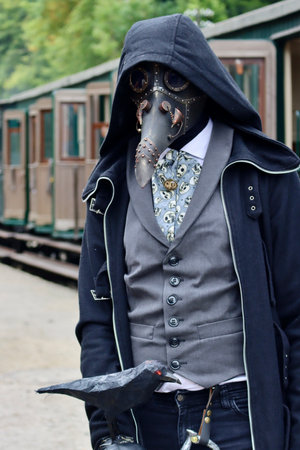Unrecognisable man in plague doctor mask at Steampunk convention on platform next to historic passenger wagons. Fond-de-Gras, Luxembourg - September 25, 2022のeditorial素材