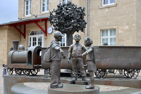Group of bronze statues of passengers and train next to train station. Diekirch, Luxembourg - September 19, 2022のeditorial素材
