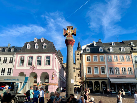 Oldest Market cross in Germany, with Latin dedication placed by Archbishop in 958, renovated 1724. Gothic houses with figures of saints behind it. Trier, Rhineland-Palatinate, Germany - September 14, 2023のeditorial素材