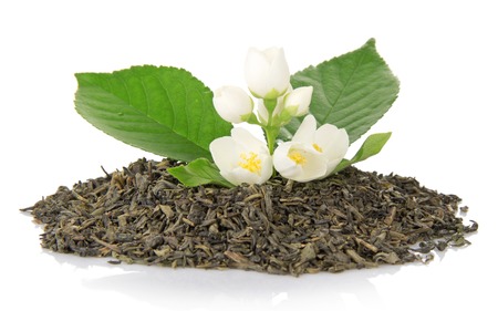 Heap of dry tea with a green leaf and flowers of the jasmine, isolated on whiteの写真素材
