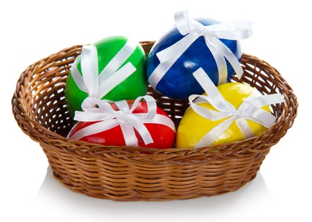 Wattled basket with the Easter eggs, isolated on whiteの写真素材