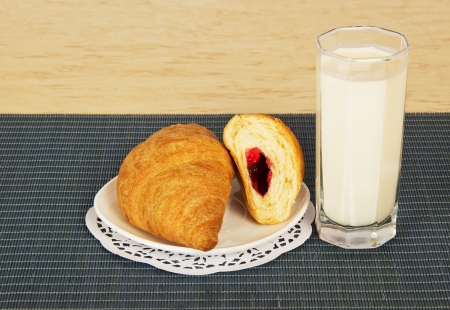 Glass of milk and croissants on a blue bamboo napkinの写真素材