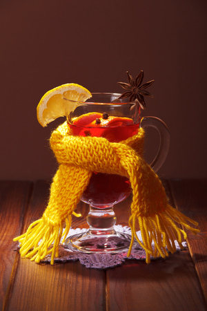 Mulled wine with orange, cloves, anise and lemon slice on a brown background.の写真素材