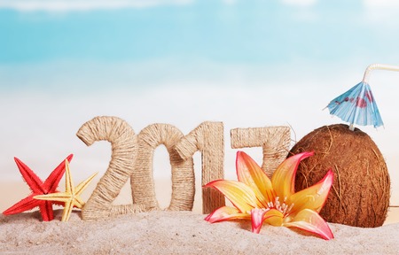New Year 2017 inscription, coconut, starfish and flowers on a background of the sea.