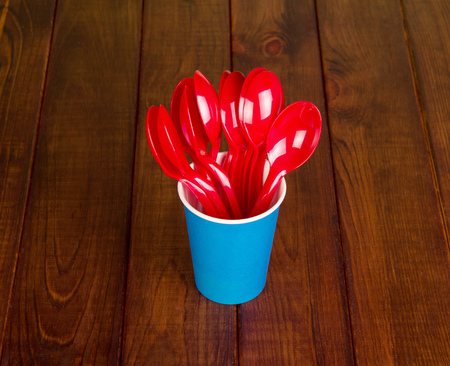 Disposable paper cup and plastic spoon on a background of dark wood.の写真素材