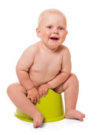 Happy little boy sits on chamber pot plastic isolated on white background.の写真素材