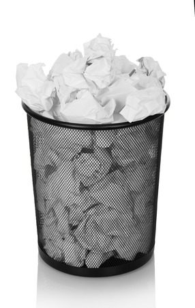 Trash can overflowing with crumpled paper isolated on white background.の写真素材
