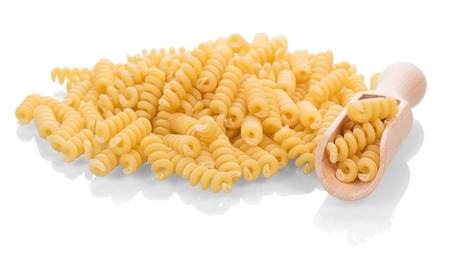 A pile of helical macaroni in a wooden scoop isolated on white background.の写真素材