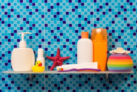 Shelf in a bathroom with the children's hygiene on abstract blue background.の写真素材