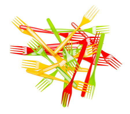 Pile of colorful plastic forks closeup isolated on white background.の写真素材