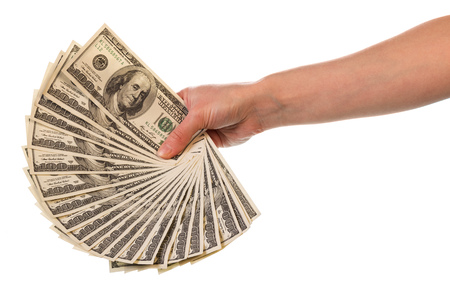 Hundred dollar bills in the female hand stacked fanned out isolated on white background.の写真素材
