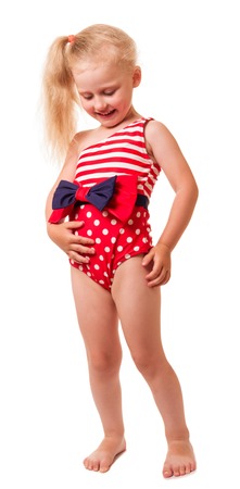 Smiling little blond girl in swimsuit looks at bow isolated on white background.の写真素材
