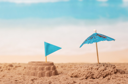 Coliseum with the flag and umbrella in the sand against the sea.の写真素材