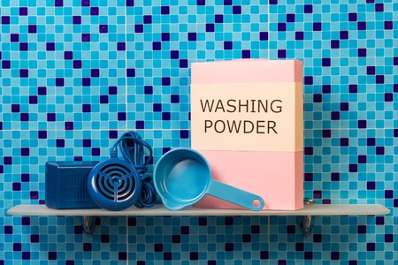 Shelf with ultrasonic washing machine, a pack of washing powder, measuring spoon on abstract blue background.の写真素材