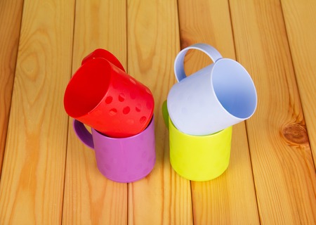 Four colorful plastic cups on the background of light wood.の写真素材