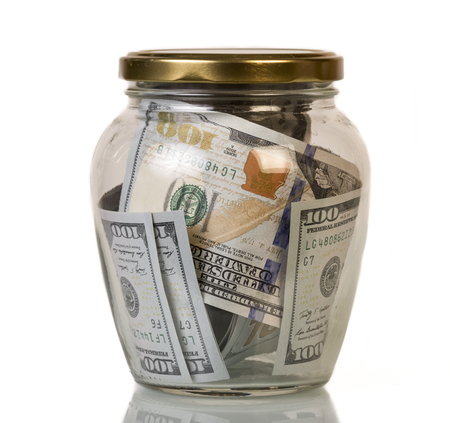 Dollars face value banknotes hundred in a glass jar isolated on white background.の写真素材